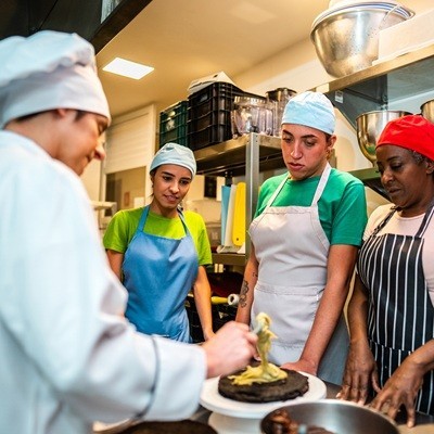 Students with chef during cooking class at bakery kitchen - Including transgender woman