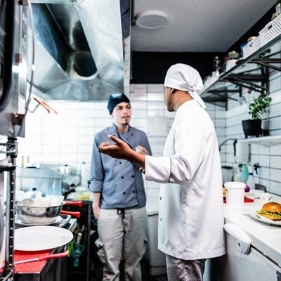 Anger chef young man talking in a commercial kitchen