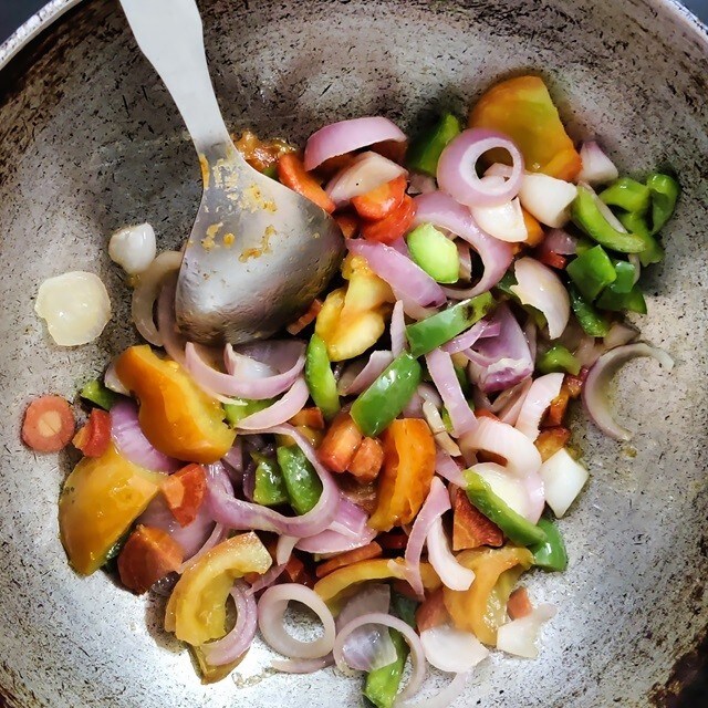 Vista superior de una sartén llena de verduras picadas que se están salteando. Vista superior de una sartén llena de verduras picadas que se están salteando.
