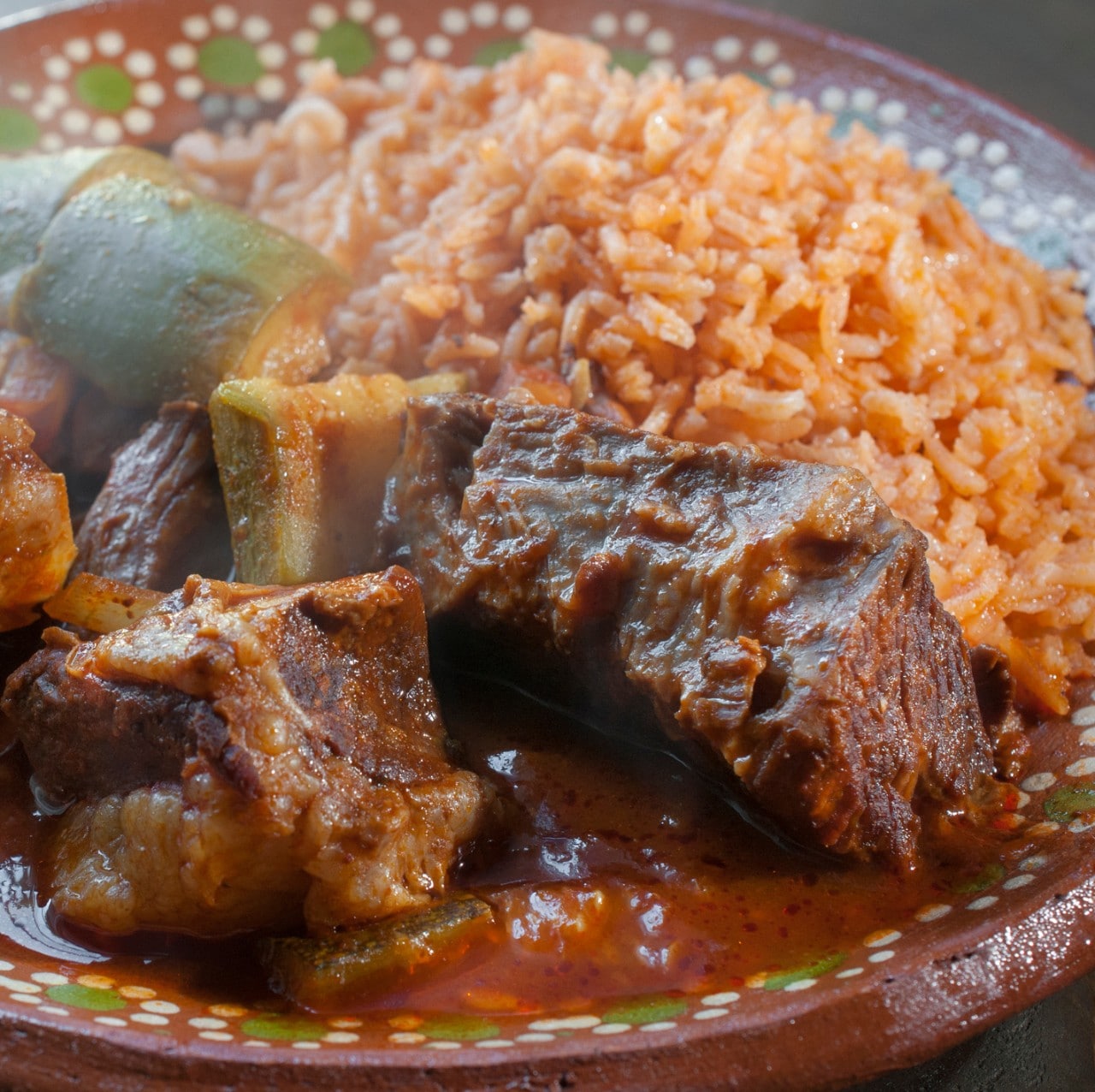 Mexican food, hot spicy ribs with Mexican rice, in a mud or clay plate
