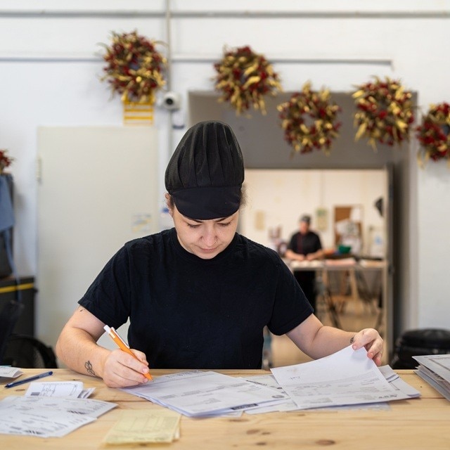 : La responsable de un restaurante trabaja en el presupuesto a fin de año, en una sala en la que hay adornos navideños.