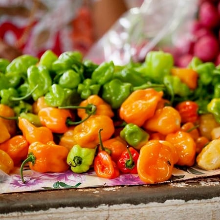 chiles habaneros verdes, naranjas y rojos sobre mesada de cocina