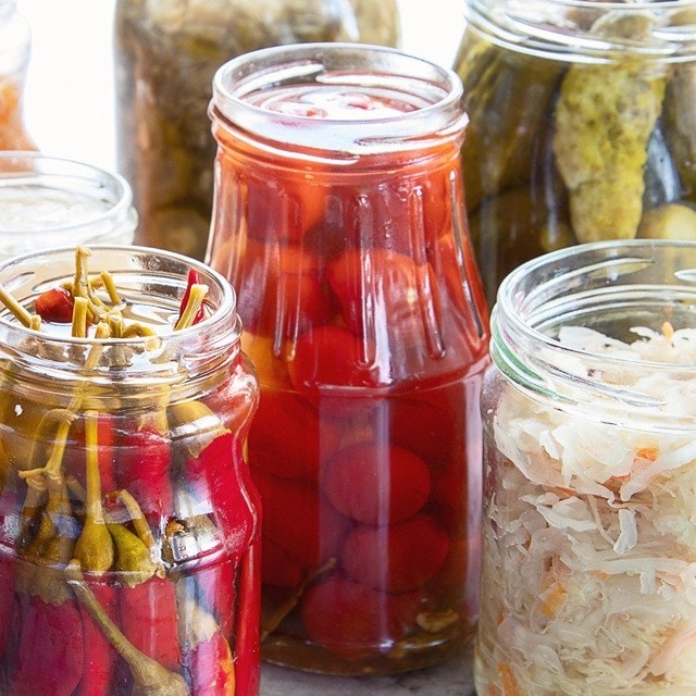 : Recipientes de vidrio con diferentes vegetales para ser fermentados, entre los que hay col blanca, chiles, tomates cereza, pepinos y salsa de jitomate, entre otros. : Recipientes de vidrio con diferentes vegetales para ser fermentados, entre los que hay col blanca, chiles, tomates cereza, pepinos y salsa de jitomate, entre otros.