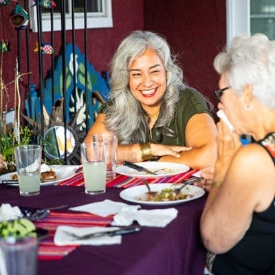 A mexican family enjoys a dinner out on the patio at home.