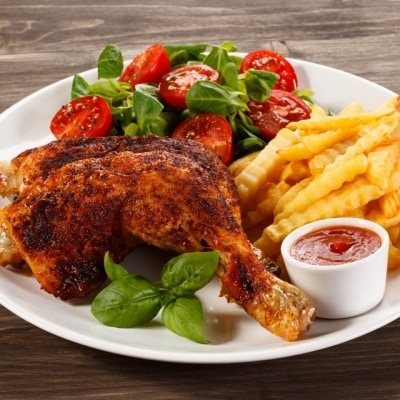 Pierna con muslo de pollo asado servido con guarniciones clásicas, como ensalada de hojas verdes y jitomate, y papas a la francesa. Está acompañado por hojas de albahaca y cátsup, en un plato blanco sobre una mesa de madera. Pierna con muslo de pollo asado servido con guarniciones clásicas, como ensalada de hojas verdes y jitomate, y papas a la francesa. Está acompañado por hojas de albahaca y cátsup, en un plato blanco sobre una mesa de madera.