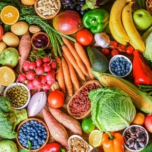 Variedad de frutas y verduras frescas y coloridas sobre una mesa de madera. Entre ellas hay naranja, camote, papa, rábanos, zanahorias, arándanos, chícharos, maíz, jitomate, limón, mango, aguacate, col, pimientos, bananas y mango. Variedad de frutas y verduras frescas y coloridas sobre una mesa de madera. Entre ellas hay naranja, camote, papa, rábanos, zanahorias, arándanos, chícharos, maíz, jitomate, limón, mango, aguacate, col, pimientos, bananas y mango.