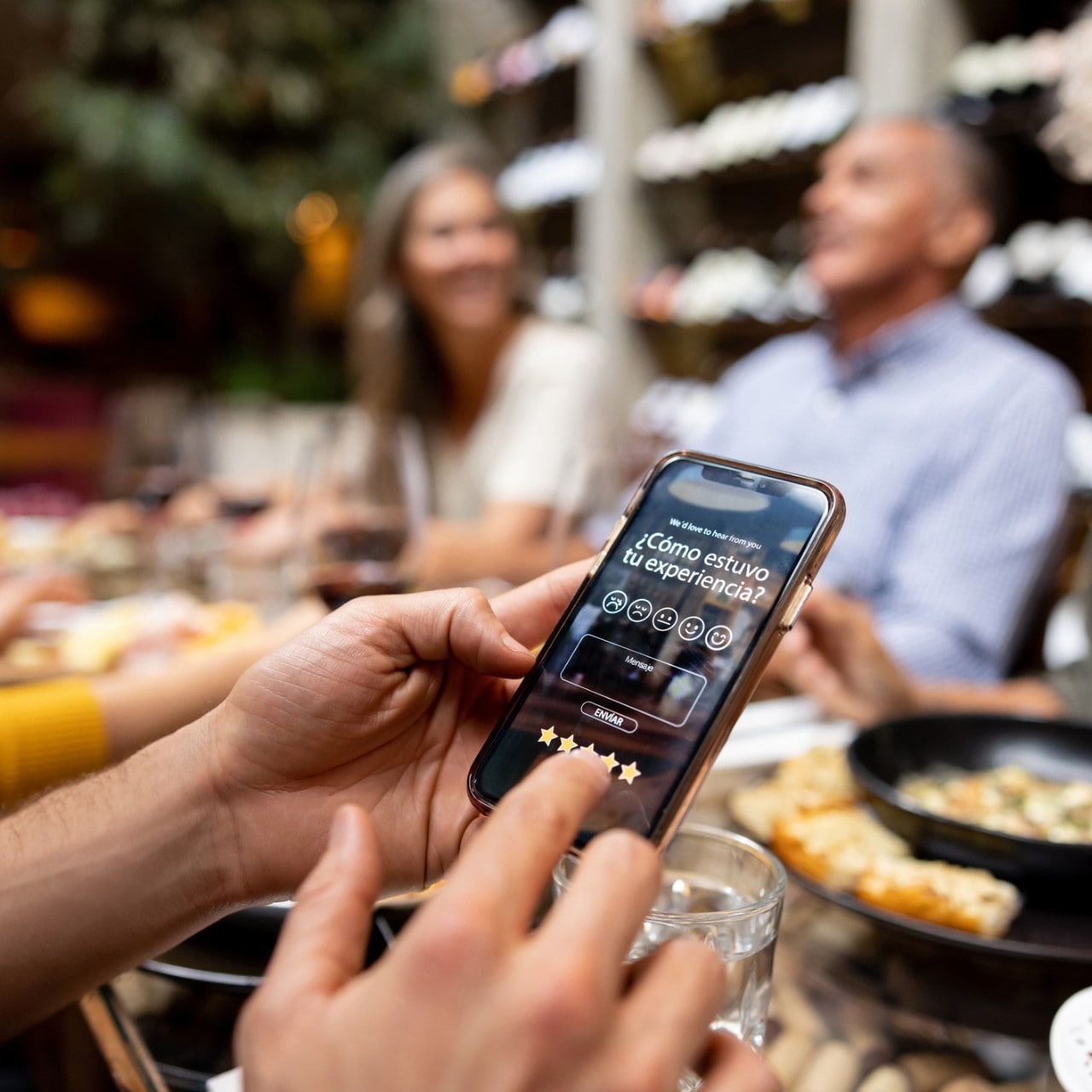Comensal utilizando el celular en una cena Comensal utilizando el celular en una cena