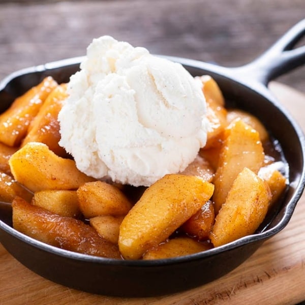 manzanas asadas con canela con yogur griego encima, sobre sartén de hierro