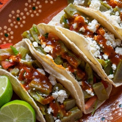 Imagen de un platillo estético, consistente en tres tacos de nopal fresco. También hay un limón cortado por la mitad. Imagen de un platillo estético, consistente en tres tacos de nopal fresco. También hay un limón cortado por la mitad.