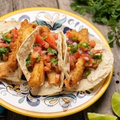 Traditional mexican breaded fish tacos also called ensenada on wooden background
