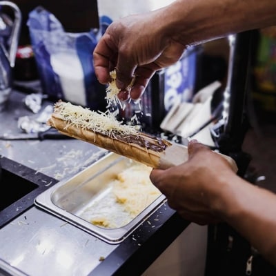 cocinero rallando queso de bola sobre marquesita, postre mexicano tradicional, comida callejera