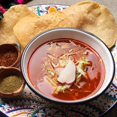 Traditional mexican red pozole on rustic background