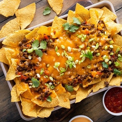 Traditional nachos with ground beef, cheddar cheese and red pepper